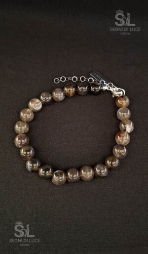 Altrove è un bracciale uomo artigianale con perle sferiche grigio venato e tabacco in resina, struttura in fibra di vetro e finiture in rodio, estetica introspettiva e materica Segni di Luce.