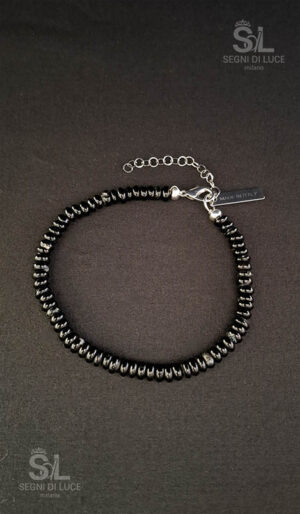 Bracciale uomo Traccia con perline schiacciate nere e grigie dalla texture minerale, estensione decorativa modulare e struttura artigianale, segno essenziale e duraturo firmato Segni di Luce.