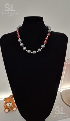 Collana statement artigianale con perle nere e gemme rosse ovali a contrasto, design elegante e deciso con chiusura regolabile argentata.