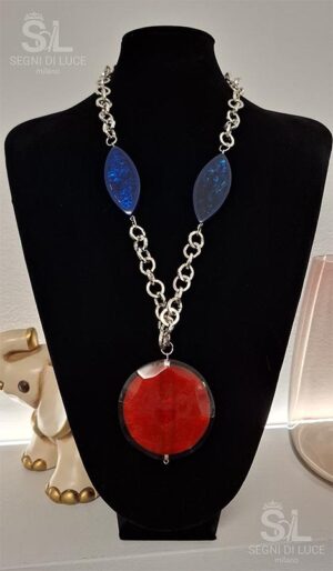 Collana statement artigianale con pietre blu a mandorla e disco centrale rosso, design scultoreo a forte contrasto cromatico.