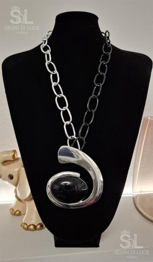 Collana statement artigianale con grande pendente asimmetrico argentato e pietra nera ovale, design minimale e deciso.
