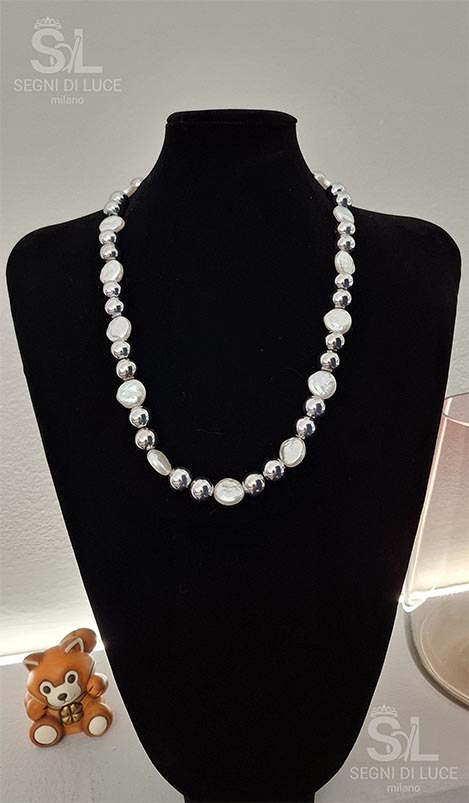 Collana artigianale pezzo unico in madreperla bianca e acciaio lucido, dal design lineare e minimal. Una collana elegante e luminosa che valorizza il décolleté con semplicità autorevole.