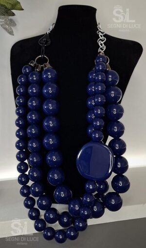 Collana statement artigianale pezzo unico con design asimmetrico in resina blu notte lucida e disco scultoreo. Un gioiello magnetico e contemporaneo.
