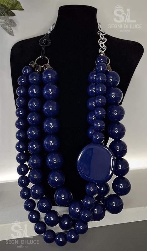Collana statement artigianale pezzo unico con design asimmetrico in resina blu notte lucida e disco scultoreo. Un gioiello magnetico e contemporaneo.