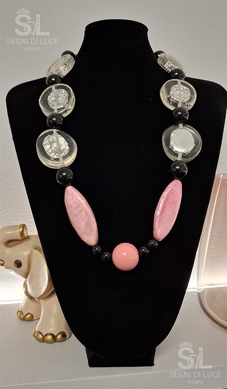 Collana pezzo unico con pietre trasparenti argentate, losanghe in madreperla rosa e perle nere lucide. Un gioiello artigianale sofisticato dal design profondo e strutturato.