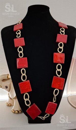 Collana statement pezzo unico con maglie dorate fluide e pietre rosse vibranti. Un gioiello artigianale che unisce energia marina e passione intensa.
