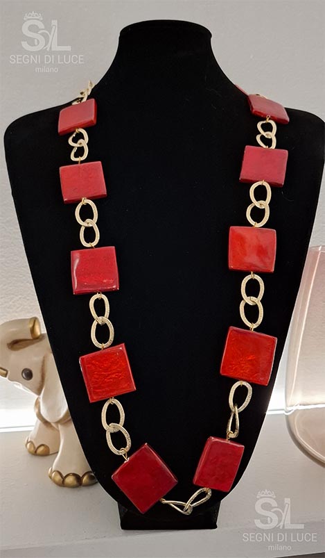 Collana statement pezzo unico con maglie dorate fluide e pietre rosse vibranti. Un gioiello artigianale che unisce energia marina e passione intensa.