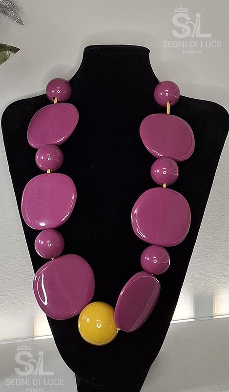 Collana statement pezzo unico in resina lucida con pietre viola levigate e elemento centrale giallo. Un gioiello audace e vibrante di forte personalità.