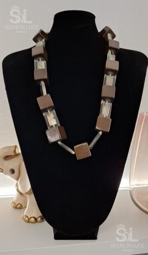 Collana statement artigianale pezzo unico in legno pregiato con geometrie scultoree e inserti trasparenti. Un design minimalista caldo e concettuale.