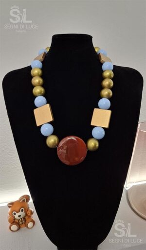 Collana statement pezzo unico in bronzo dorato e azzurro cielo con ciondolo centrale. Un gioiello artigianale dal design regale e bilanciato.