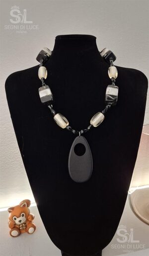 Collana artigianale pezzo unico in tonalità stratificate di nero, grigio e bianco. Design scultoreo sobrio e raffinato per un’eleganza senza tempo.