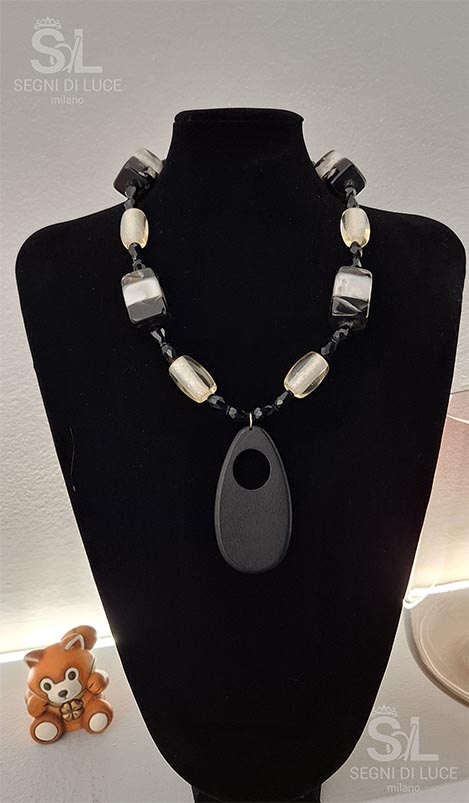 Collana artigianale pezzo unico in tonalità stratificate di nero, grigio e bianco. Design scultoreo sobrio e raffinato per un’eleganza senza tempo.