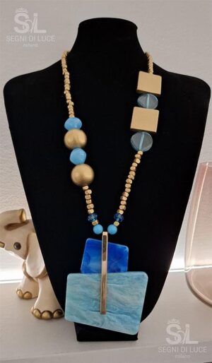 Collana statement pezzo unico dal design asimmetrico con grande pendente azzurro e elementi in bronzo dorato. Un gioiello artigianale audace e monumentale.