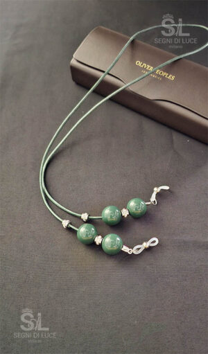 Cordoncino reggi-occhiali donna artigianale in eco-cuoio verde salvia con perle coordinate e dettagli luminosi. Accessorio pezzo unico realizzato a mano da Segni di Luce.