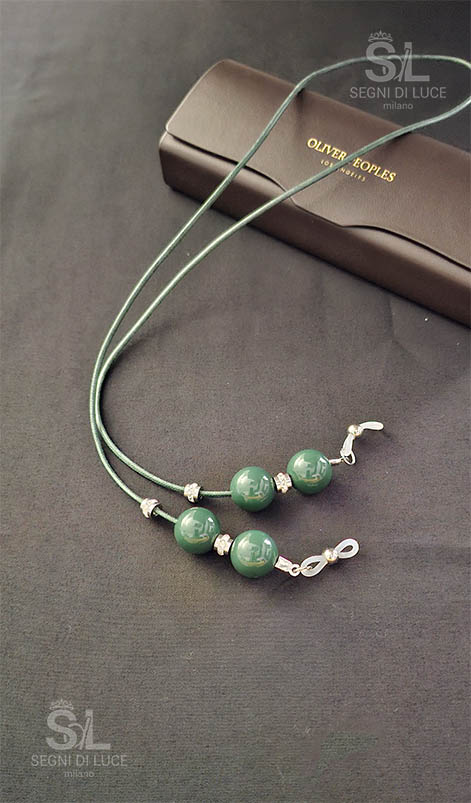 Cordoncino reggi-occhiali donna artigianale in eco-cuoio verde salvia con perle coordinate e dettagli luminosi. Accessorio pezzo unico realizzato a mano da Segni di Luce.